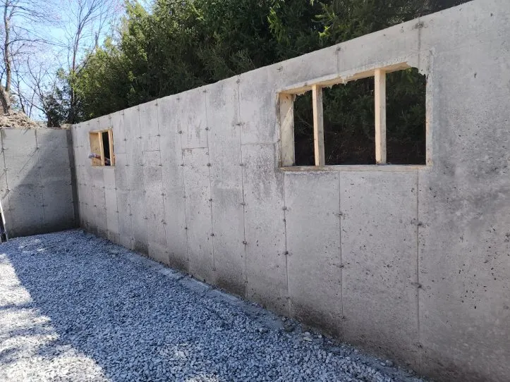 Ouvertures de fenêtres ménagées dans le mur de béton, plancher de pierre nette au soleil