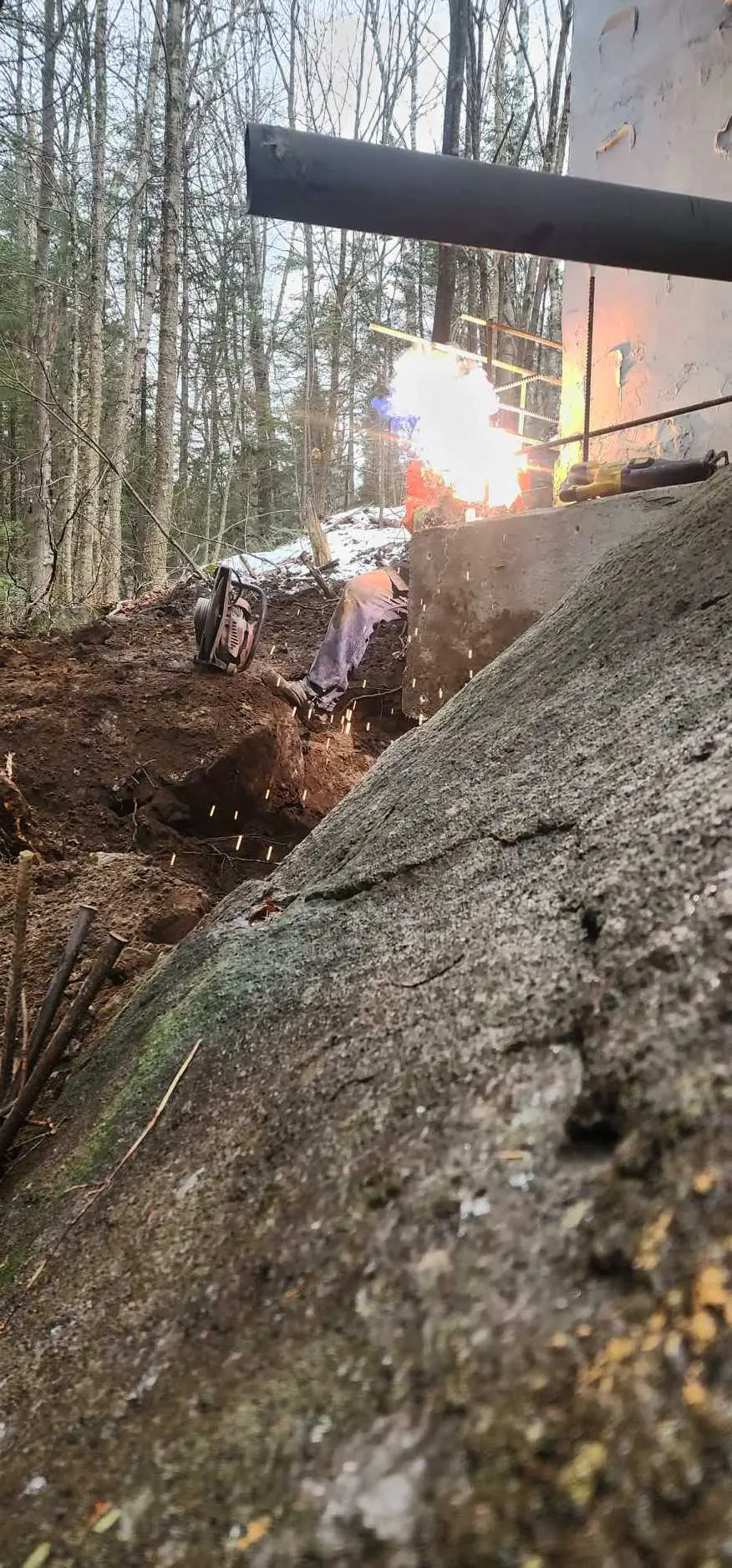 Soudure d'une poutre d'acier au-dessus d'une tranchée, gerbe d'étincelles bien visible