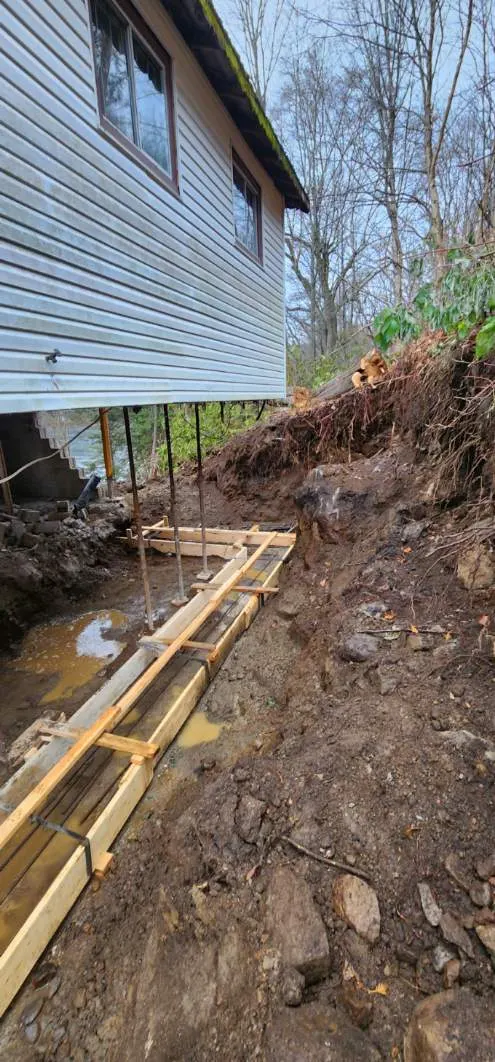 Tranchée étroite creusée le long du mur latéral avant le coffrage de la fondation