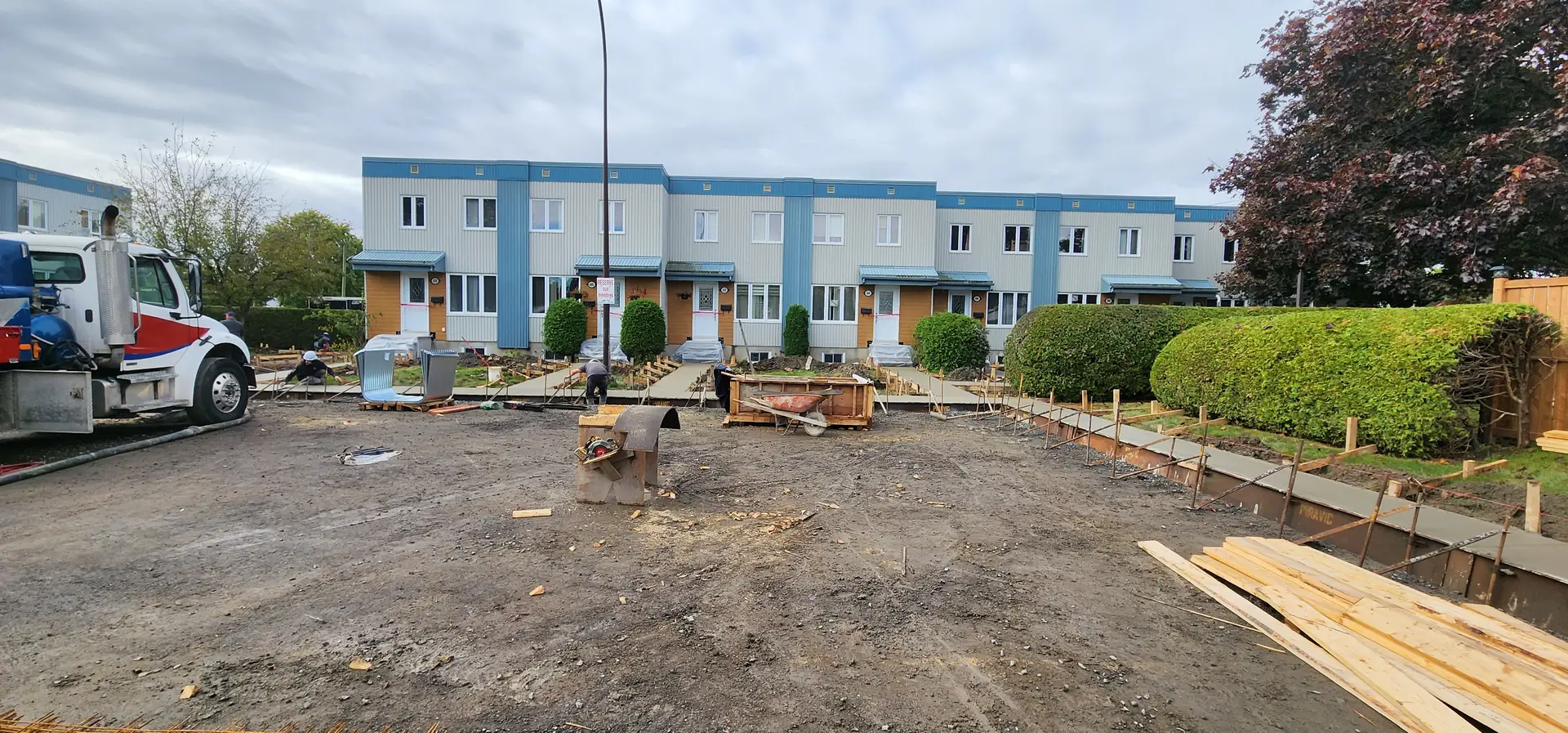 Trottoir de béton | Stabili Pieux Chantier de trottoir en préparation : sol de gravier et coffrages de bois alignés